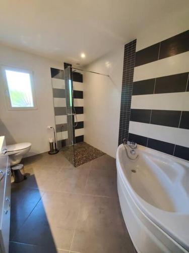 La salle de bains est pourvue d'une grande baignoire et d'une douche. dans l'établissement La Cersoise, 10 min des plages, à Cers