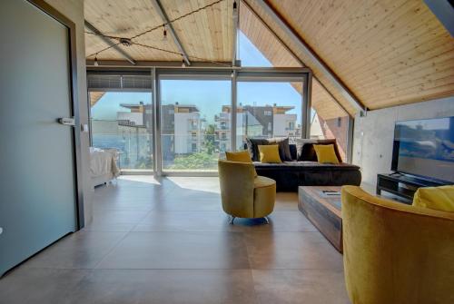 a living room with a couch and a television at HelApart - Loft in Hel
