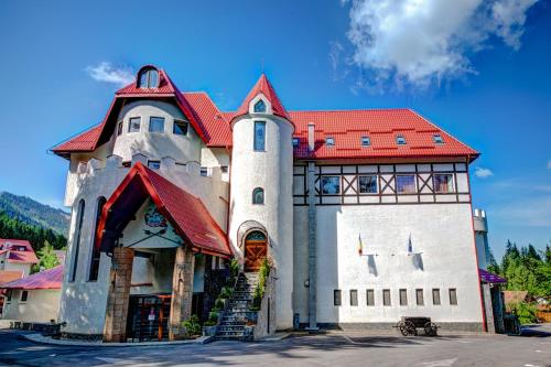 a large building with a red roof at House of Dracula Hotel in Poiana Brasov