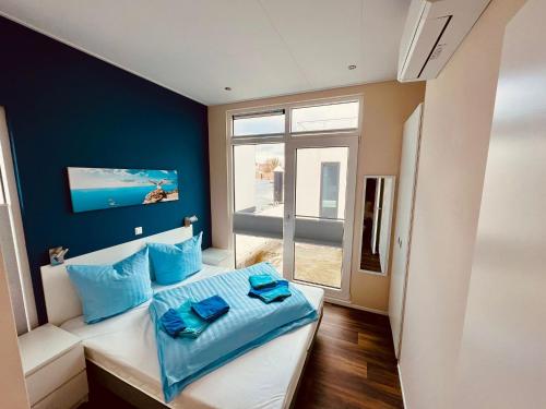 1 dormitorio con paredes azules y 1 cama con almohadas azules en schwimmendes Haus Lütte, en Ribnitz-Damgarten