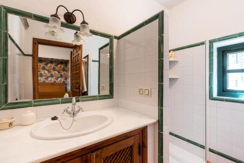 y baño con lavabo y espejo. en Casa Alta Finca El Revuelo, en Las Navas de la Concepción