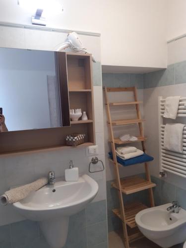 ein Bad mit einem Waschbecken und einem Spiegel in der Unterkunft B&By in viaggio in Putignano