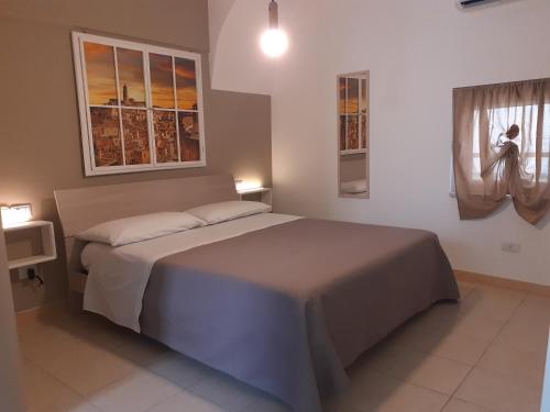 ein Schlafzimmer mit einem großen Bett und zwei Fenstern in der Unterkunft B&By in viaggio in Putignano
