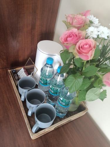 a tray with water bottles and a bouquet of pink roses at Pokoje Bakos Radocza in Radocza
