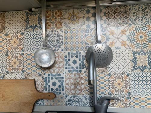 Casa dai Toni Cortesi 2 في بيرغامو: مطبخ مع جدار من البلاط مع أدوات المائدة