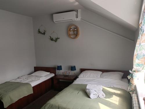 two twin beds in a room with towels on them at Pokoje Bakos Radocza in Radocza