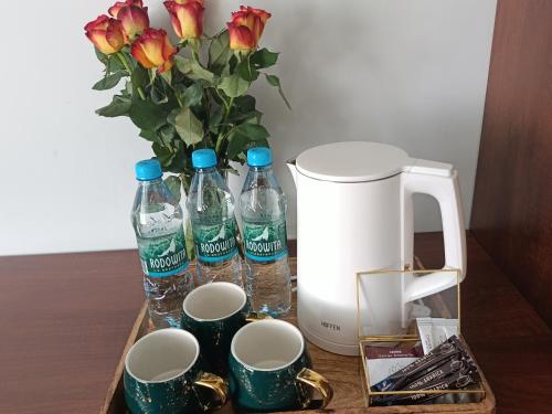 a table with two bottles of water and a vase with flowers at Pokoje Bakos Radocza in Radocza