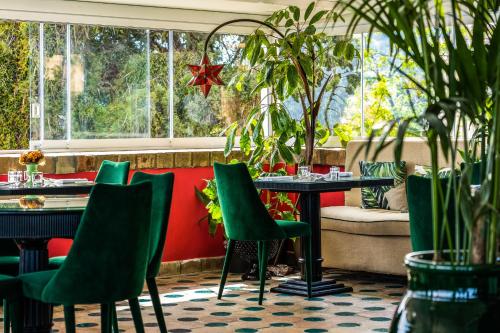 a restaurant with green chairs and a table at Hotel Villa Carlotta in Taormina