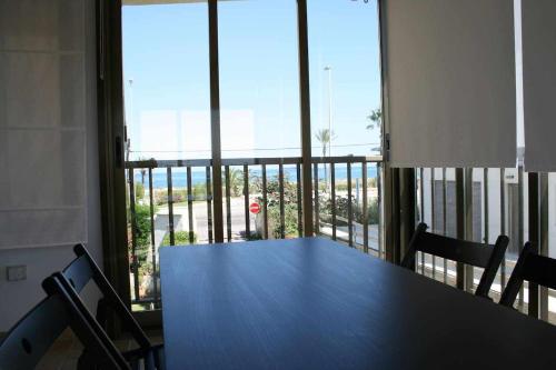 グラオ・デ・カステヨンにあるLas Minvas Relaxの大きな窓のある客室で、テーブルと椅子が備わります。