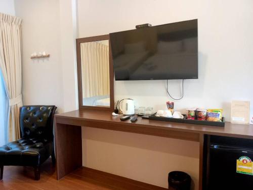 a desk with a flat screen tv on a wall at Blue Orchid Beach Krabi - SHA Certified in Ao Nam Mao