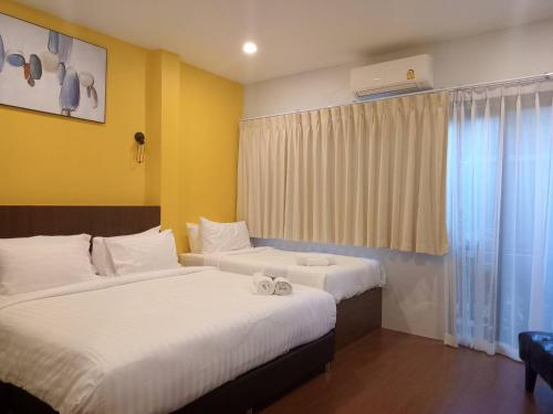 a hotel room with two beds and a window at Blue Orchid Beach Krabi - SHA Certified in Ao Nam Mao