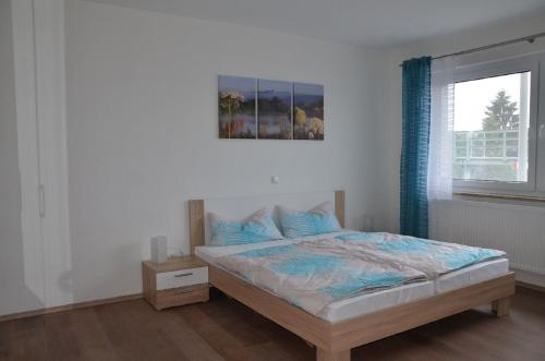 1 dormitorio con 1 cama con una foto en la pared en Obsthof Flammersberger, en Volkach