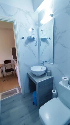 a white bathroom with a sink and a toilet at Zacharogianni Studios in Nikiana