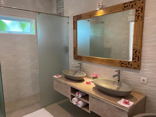 2 lavabos en un baño con espejo en Ceningan Beachside Villas en Lembongan