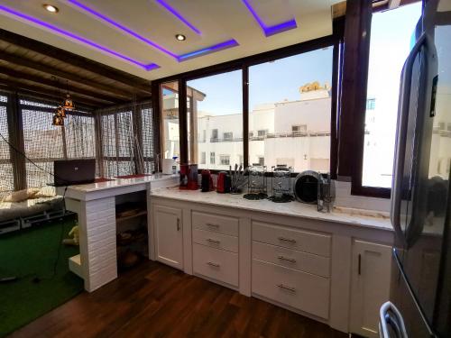 a kitchen with a counter and some windows at Big, stylish and modern apartment with hot tub in Tangier