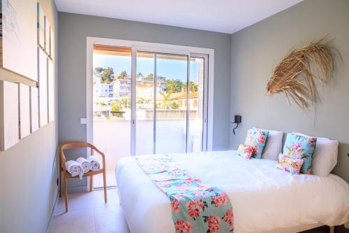 um quarto com uma cama branca e uma varanda em "Sea La Vie" - Croisette - 30 m plage - Palais - Congrès - Parking Privé - Clim em Cannes