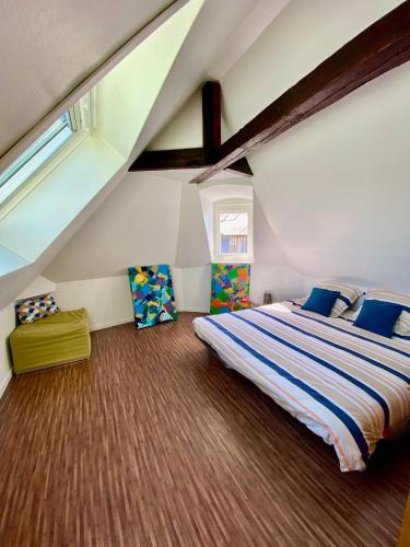 une chambre avec un grand lit dans un grenier dans l'établissement Toutes voiles dehors - Vue mer & château - Cosy, à Dieppe