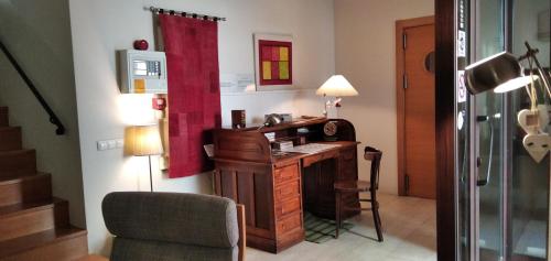 Habitación con escritorio, silla y lámpara. en Petit Hotel Porrera en Porrera