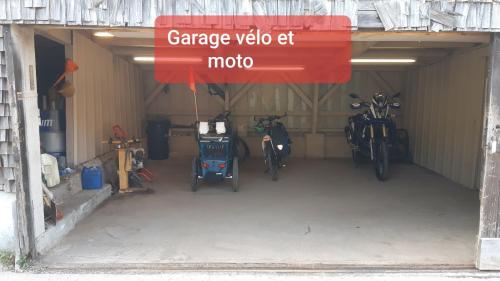 un garage avec des motos garées à l'intérieur du garage dans l'établissement Auberge du Grammont, à Ramonchamp