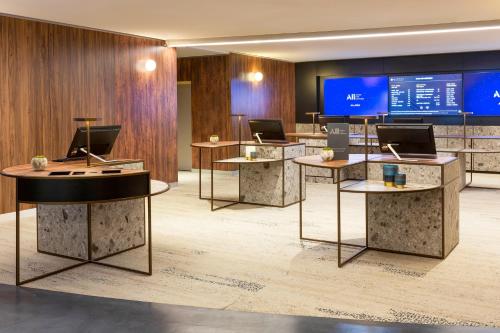 a lobby with several tables with laptops on them at Pullman Paris Montparnasse in Paris