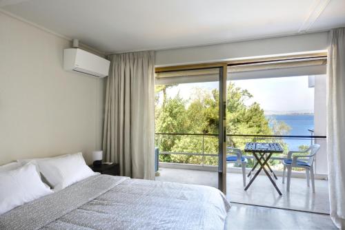 a bedroom with a bed and a view of the ocean at Kavouri Flat in Athens