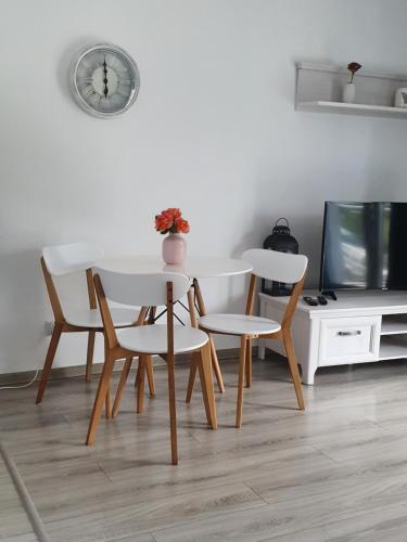 a table and chairs in a living room with a tv at Narutowicza Modern Apartment 2 in Słupsk