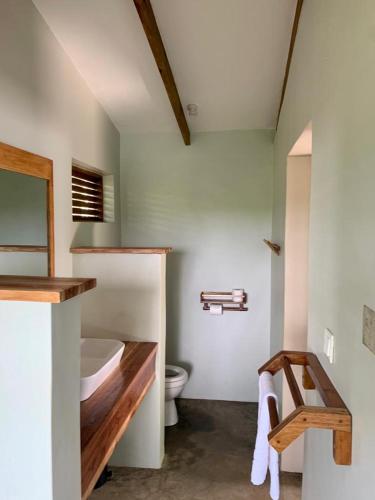 Un baño con lavabo e inodoro en una habitación. en Adrift River Club, en Kangulumira