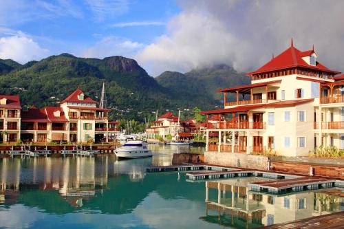 a group of buildings on a body of water with mountains at Eden Island Luxury Accommodation in Eden Island
