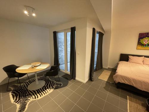 a bedroom with a bed and a table with a zebra rug at Studio Just For 2 in Ostend