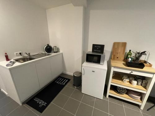a small kitchen with a sink and a microwave at Studio Just For 2 in Ostend
