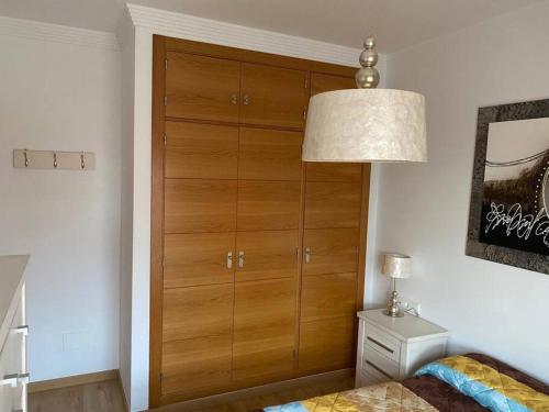 una camera da letto con un grande armadio in legno con lampada di Apartamento Club Nautico By Solymar Holiday a Torre del Mar