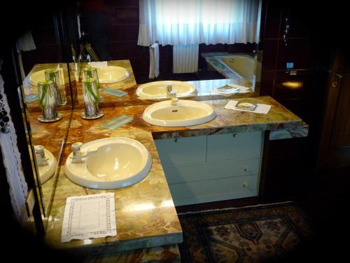a bathroom with three sinks and a marble counter at B&B Cà d'Artisti in Caorle
