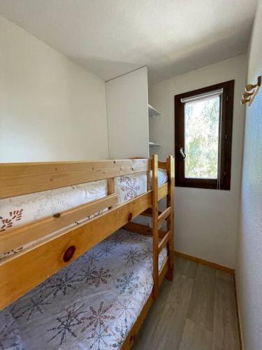 une chambre avec deux lits superposés et une fenêtre dans l'établissement Appartement aux pieds des pistes - La Plagne Montalbert - Panorama 1350, à Aime La Plagne