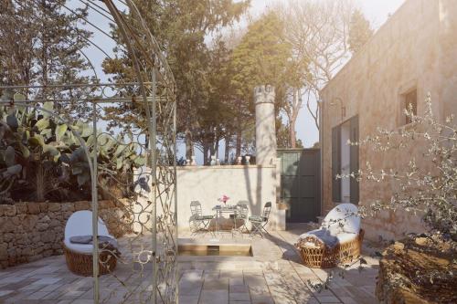 a courtyard with a table and chairs and a building at Castle Elvira - The Castle & The Cottage in Trepuzzi
