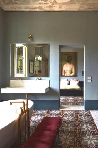 a bathroom with a sink and a bed with a mirror at Castle Elvira - The Castle & The Cottage in Trepuzzi