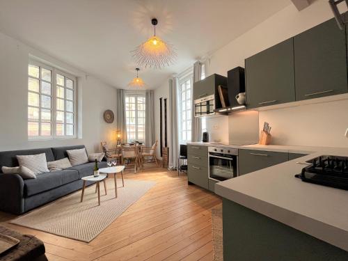 une cuisine et un salon avec un canapé et une table dans l'établissement L emeraude - Trouville, à Trouville-sur-Mer