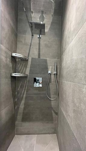 La salle de bains est pourvue d'une douche et d'un ordinateur portable sur le mur. dans l'établissement L emeraude - Trouville, à Trouville-sur-Mer