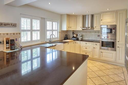 a large kitchen with white cabinets and stainless steel appliances at Host & Stay - Doray House in Newton-by-the-Sea