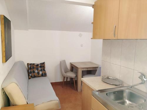 una piccola cucina con divano e tavolo di Apartmani Abeona a Budua