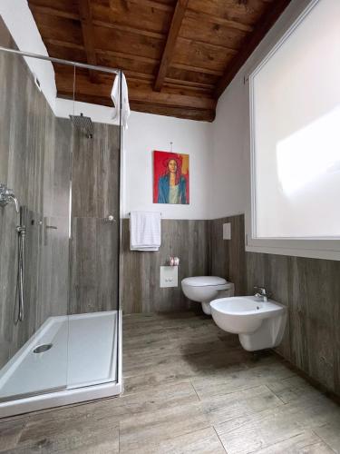 a bathroom with two toilets and a shower and a sink at Alkimia Smart Rooms in Ferrara