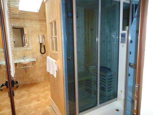 y baño con ducha acristalada y lavamanos. en Family Hotel Shipkovo, en Shipkovo
