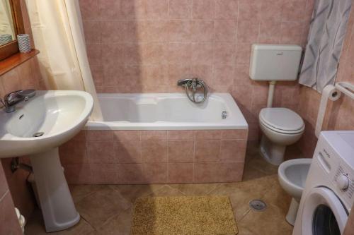 a bathroom with a sink and a tub and a toilet at I Trulli D'a Ross in Ceglie Messapica