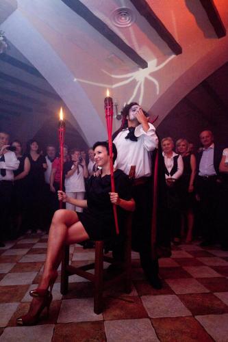 two people sitting in a chair with candles in a room at House of Dracula Hotel in Poiana Brasov