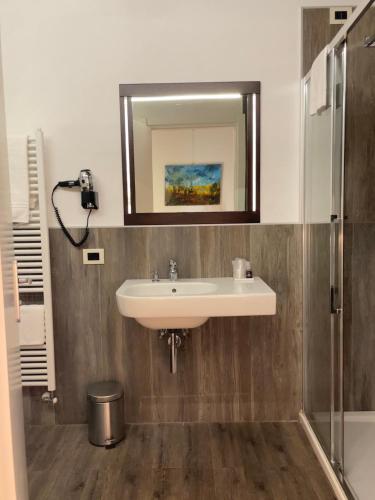 a bathroom with a sink and a mirror at Alkimia Smart Rooms in Ferrara