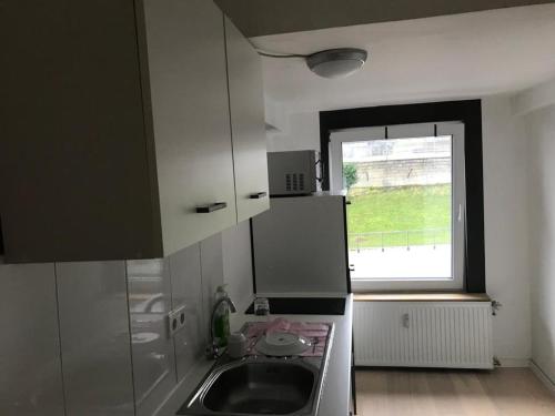 a small kitchen with a sink and a window at Fewo Meschede Eversberg Radring in Meschede