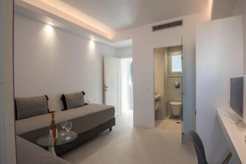 Zimmer mit einem Bett, einem Tisch und einem TV in der Unterkunft Alexandros Apartments in Naoussa