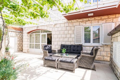 eine Terrasse mit Korbstühlen und einem Sofa in der Unterkunft Holiday Home King in Dubrovnik