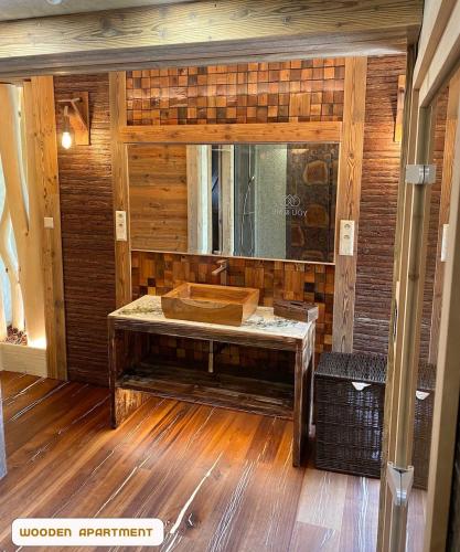 a wooden bathroom with a sink and a mirror at You and Me Apartments in Prosenická Lhota