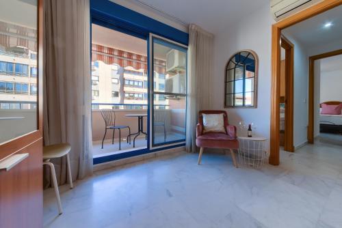 um quarto com uma grande janela e uma mesa e cadeiras em Holidays2Malaga Ayala 450 mts from beach & Terrace em Málaga