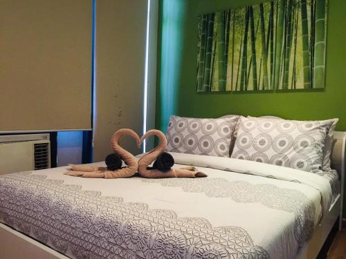 two stuffed animals are laying on a bed at Taguig 1 Bedroom with balcony Grace Residences Near Bgc in Manila